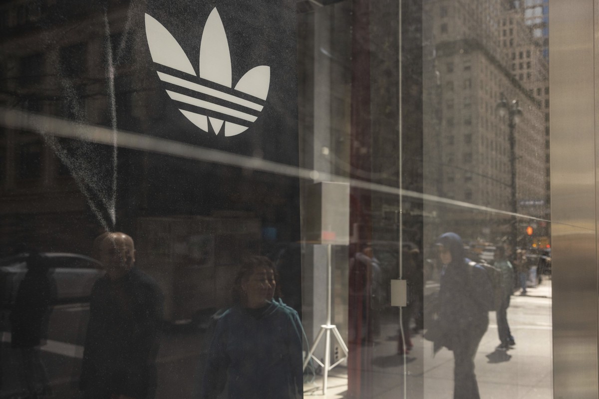 dpatopbilder - 08.04.2025, USA, New York: Fußgänger spiegeln sich in einem Schaufenster eines Adidas-Geschäfts auf der 5th Avenue. Foto: Yuki Iwamura/AP/dpa +++ dpa-Bildfunk +++