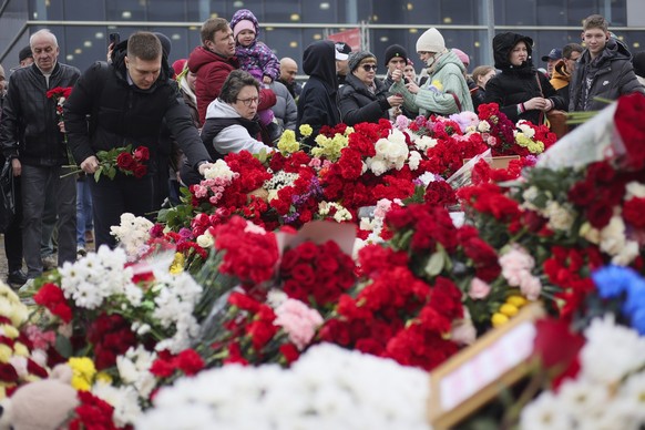 dpatopbilder - 24.03.2024, Russland, Moskau: Menschen legen Blumen und Spielzeug am Zaun neben der Veranstaltungshalle Crocus City Hall ab. Die Terrormiliz Islamischer Staat hatte die Tat bereits in d ...