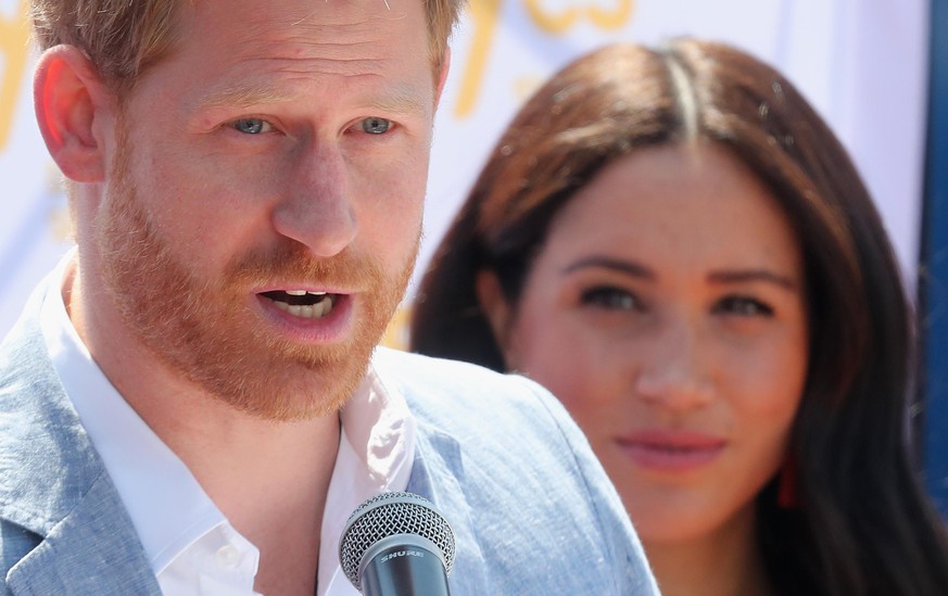 JOHANNESBURG, SOUTH AFRICA - OCTOBER 02: Meghan, Duchess of Sussex looks on as Prince Harry, Duke of Sussex speaks during a visit a township to learn about Youth Employment Services on October 02, 201 ...