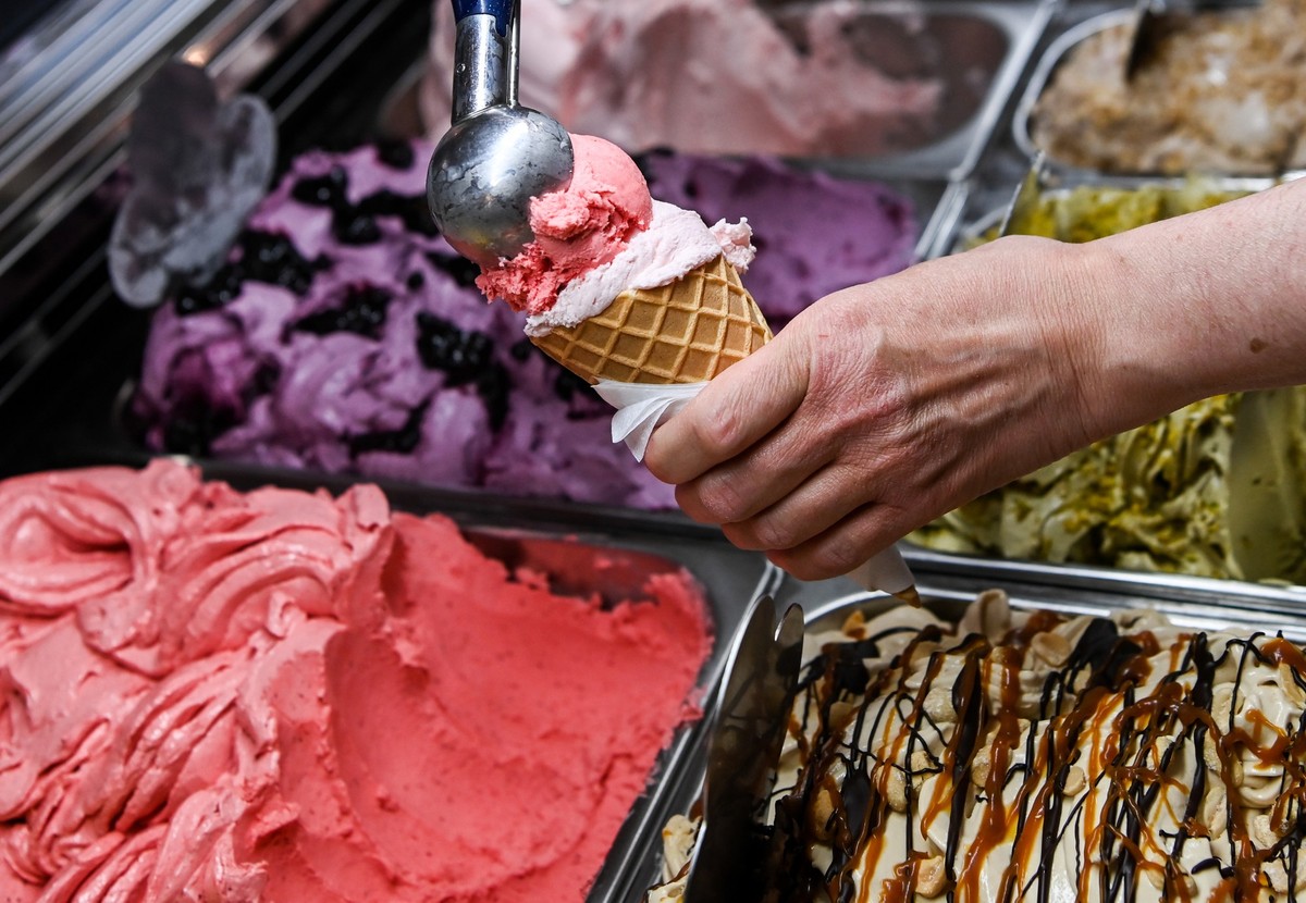 ARCHIV - 24.05.2022, Berlin: Eine Kugel Erdbeereis wird in einer Eisdiele auf eine weitere Kugel in einem Waffelhörnchen gesetzt. (zu dpa: «Ist Eis zu teuer? Kugelpreise entfachen Frust») Foto: Jens K ...