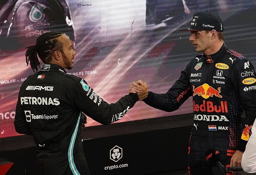 ARCHIV - 12.12.2021, Vereinigte Arabische Emirate, Abu Dhabi: Motorsport: Formel-1-Weltmeisterschaft, Grand Prix von Abu Dhabi, Rennen. Lewis Hamilton (l) aus Großbritannien vom Team Mercedes gratulie ...