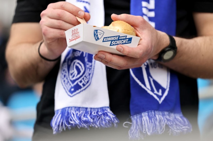 BOCHUM, GERMANY - APRIL 22: A fan of Bochum eats a curry sausage prior to the Bundesliga match between VfL Bochum 1848 and VfL Wolfsburg at Vonovia Ruhrstadion on April 22, 2023 in Bochum, Germany. (P ...