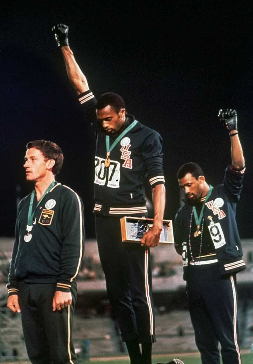 FILE - In this Oct. 16, 1968, file photo, U.S. athletes Tommie Smith, center, and John Carlos stare downward as they extend gloved hands skyward in during the playing of the &quot;Star Spangled Banner ...