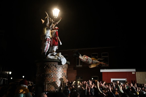 06.12.2024, Niedersachsen, Borkum: Die Klaasohms springen zum Abschluss des Klaasohms 2024 nacheinander von der Säule des Vereins Borkumer Jungens. Nikolaus-Tradition &quot;Klaasohm&quot; auf der Nord ...
