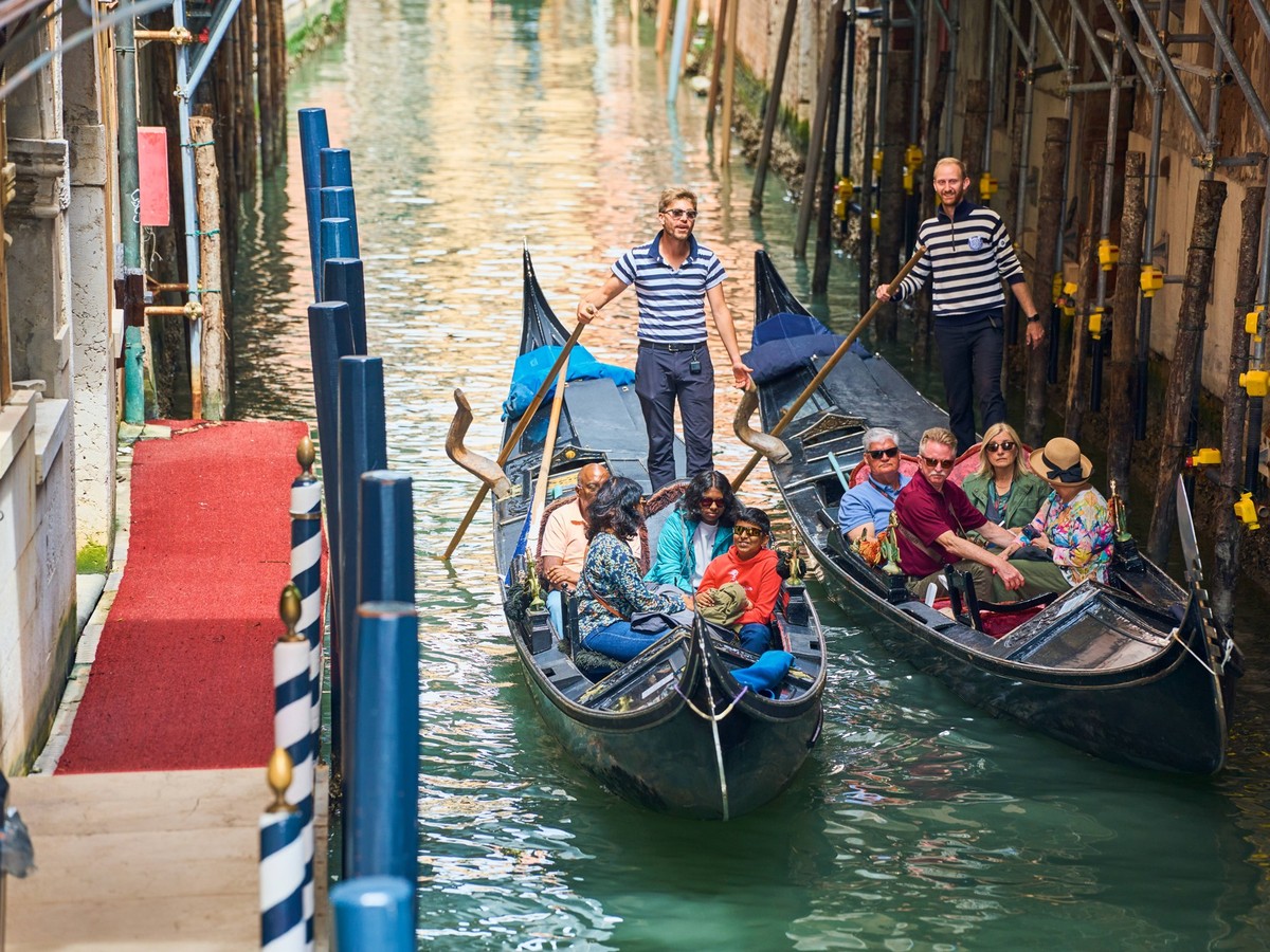 Venice, Italy - May 3, 2024: Gondolier takes tourists on a gondola ride through the picturesque city of Venice in Italy *** Gondoliere f