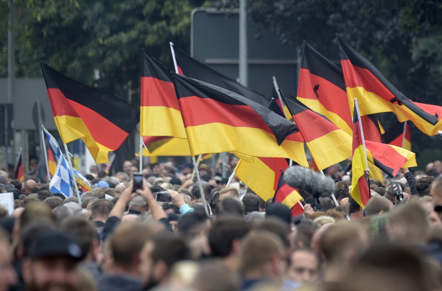 Demonstrators carry German flags during a demonstration in Chemnitz, eastern Germany, Saturday, Sept. 1, 2018, after several nationalist groups called for marches protesting the killing of a German ma ...