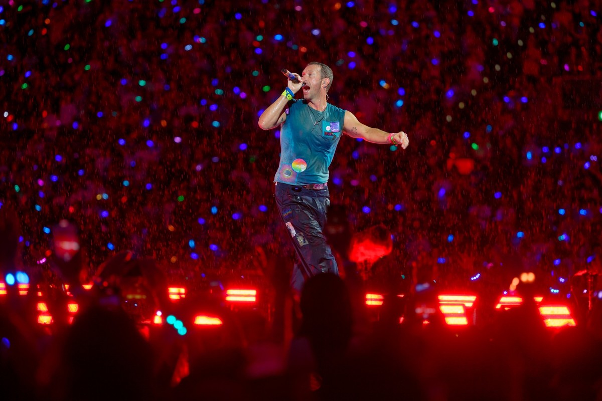 20.07.2024, Nordrhein-Westfalen, Düsseldorf: Chris Martin, Sänger der britischen Band Coldplay steht bei einem Konzert im Rahmen der &quot;Music of the Spheres Tour 2024&quot; bei strömendem Regen in  ...