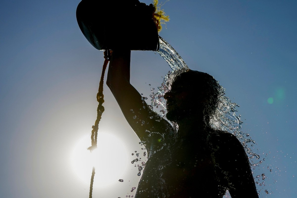16.07.2024, Libanon, Beirut: Ein Mann spült sich mit frischem Wasser ab, nachdem er an einem brütend heißen Tag am öffentlichen Strand von Ramlet al-Baida Beachvolleyball gespielt hat. Foto: Hassan Am ...
