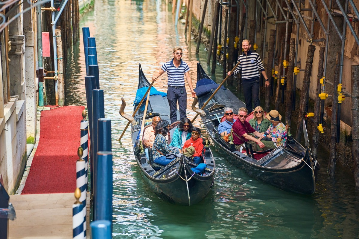 Venice, Italy - May 3, 2024: Gondolier takes tourists on a gondola ride through the picturesque city of Venice in Italy *** Gondoliere f