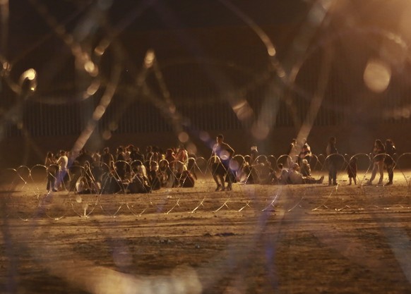 11.05.2023, Mexiko, Ciudad Juarez: Migranten warten auf die US-Behörden am Tor 42, zwischen einer Stacheldrahtbarriere und dem Grenzzaun an der Grenze zwischen den USA und Mexiko. Kurz vor dem Auslauf ...