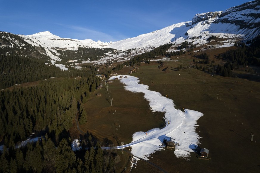 Schweiz, Flims: Blick auf die Talabfahrt aus Kunstschnee (Aufnahme mit einer Drohne). In vielen Wintersportgebieten ist es derzeit eher grün statt weiß.