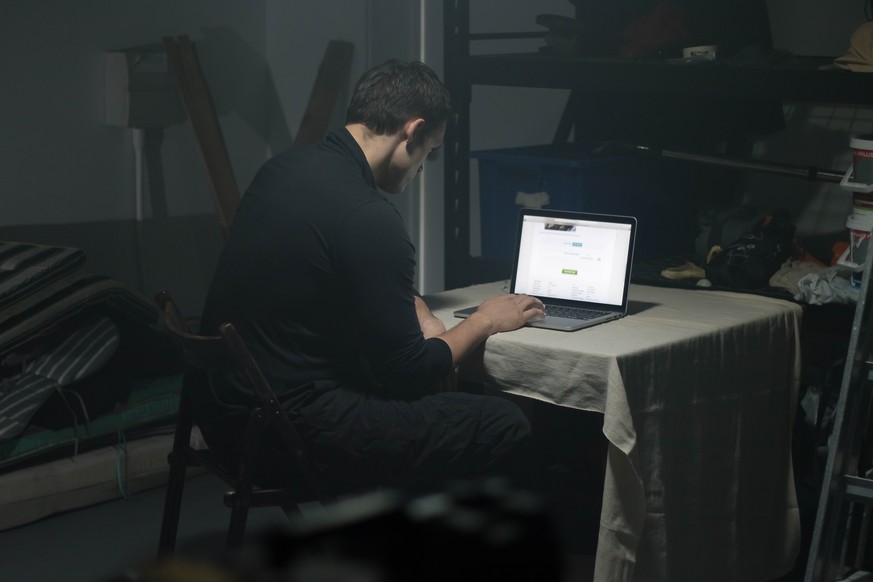 Man using laptop in a dark room.