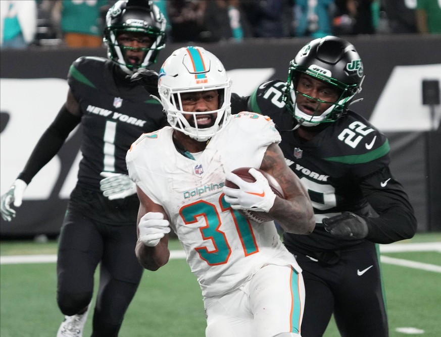 Syndication: The Record East Rutherford, NJ November 24, 2023 -- Raheem Mostert of Miami is pursued by Sauce Gardner and Tony Adams of the Jets but not before scoring one of his TDs in the second half ...