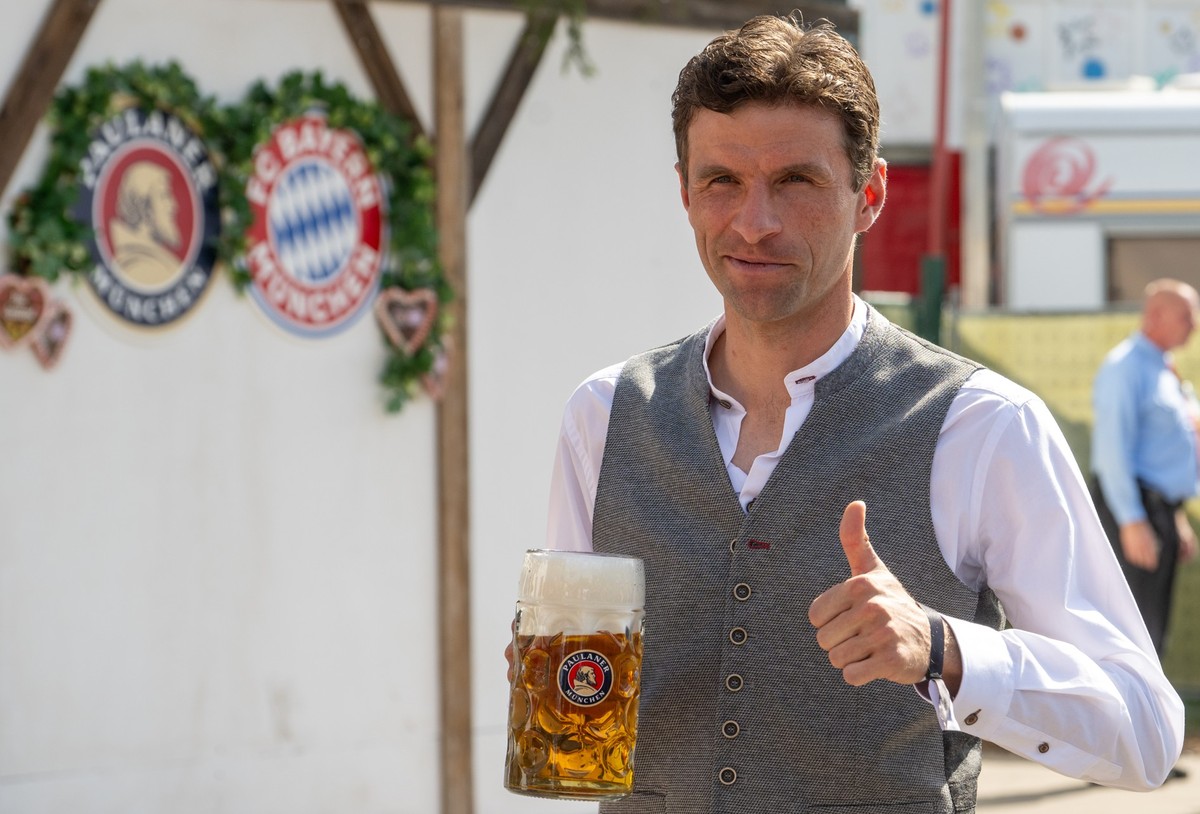 22.09.2024, Bayern, München: Thomas Müller vom FC Bayern München hält auf dem Oktoberfest vor Käfer&#039;s Wiesn-Schänke einen Maßkrug. Die Spieler des FC Bayern besuchen traditionell zum Wiesnauftakt ...