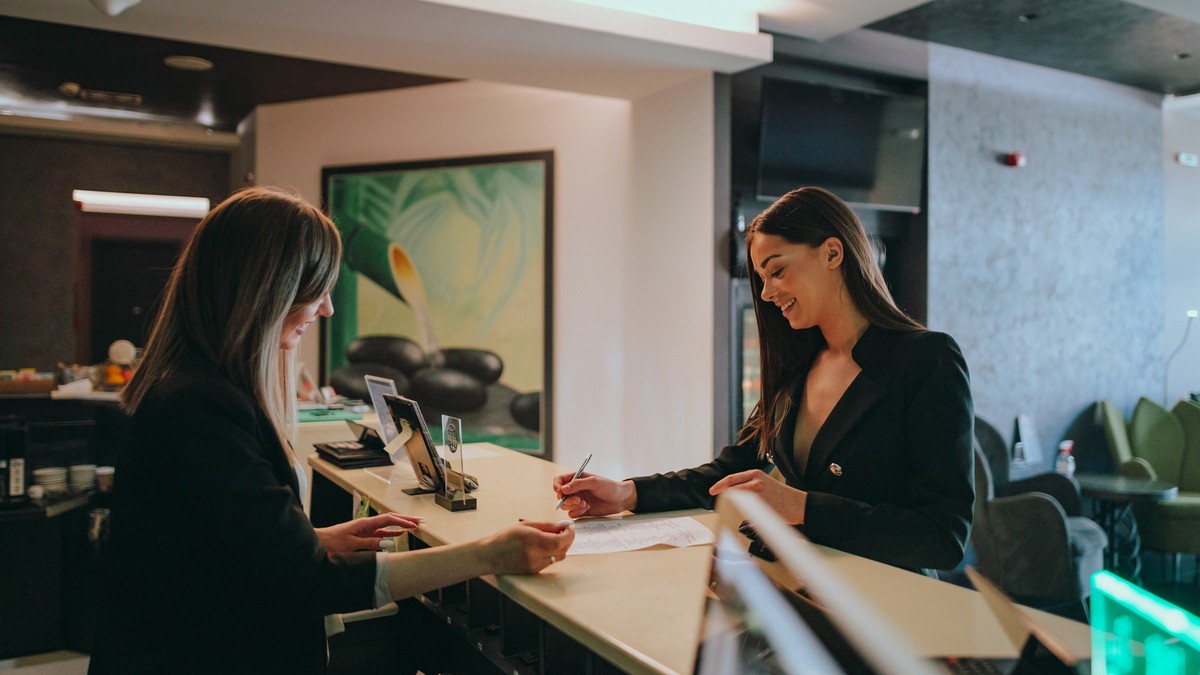 Young woman wearing a suit traveling for business check-in at the hotel reception