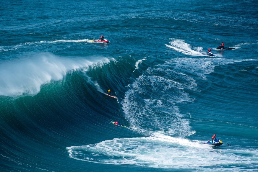 The surfers sailing in the Atlantic Ocean near the Nazare municipality in Portugal