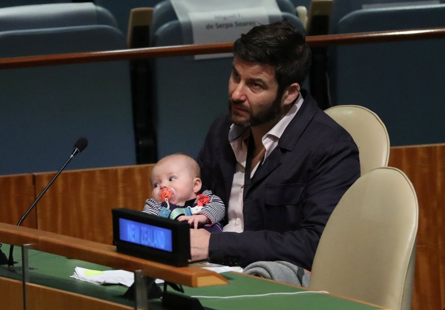 Clarke Gayford, partner to New Zealand Prime Minister Jacinda Ardern holds their baby Neve as Ardern speaks at the Nelson Mandela Peace Summit during the 73rd United Nations General Assembly in New Yo ...