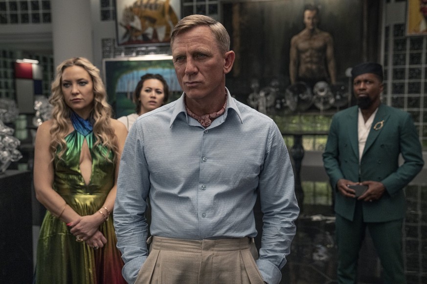 This image released by Netflix shows Kate Hudson, from left, Jessica Henwick, Daniel Craig and Leslie Odom Jr. in a scene from &quot;Glass Onion: A Knives Out Mystery.&quot; (John Wilson/Netflix via A ...