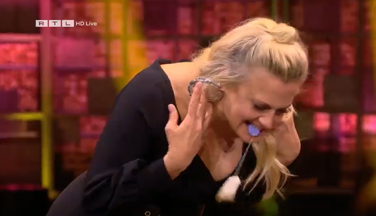 Barbara Schöneberger schwingt den Teebeutel und will ihn in eine Teetasse schleudern.