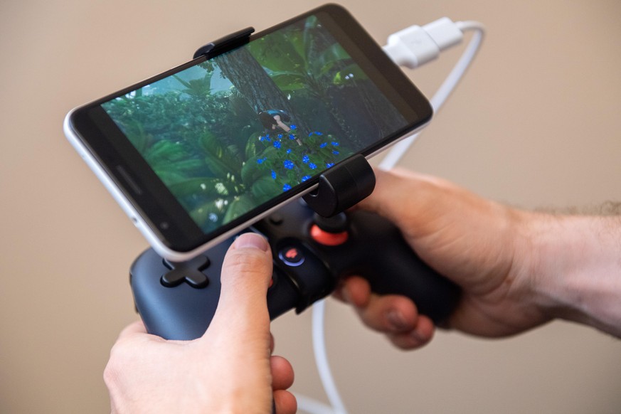 ILLUSTRATION - Ein Mann spielt am 18.11.2019 auf einem Smartphone in Berlin den Spiele-Dienst Google Stadia das Spiel Shadow of the Tomb Raider (gestellte Szene). Foto: Andrea Warnecke | Verwendung we ...