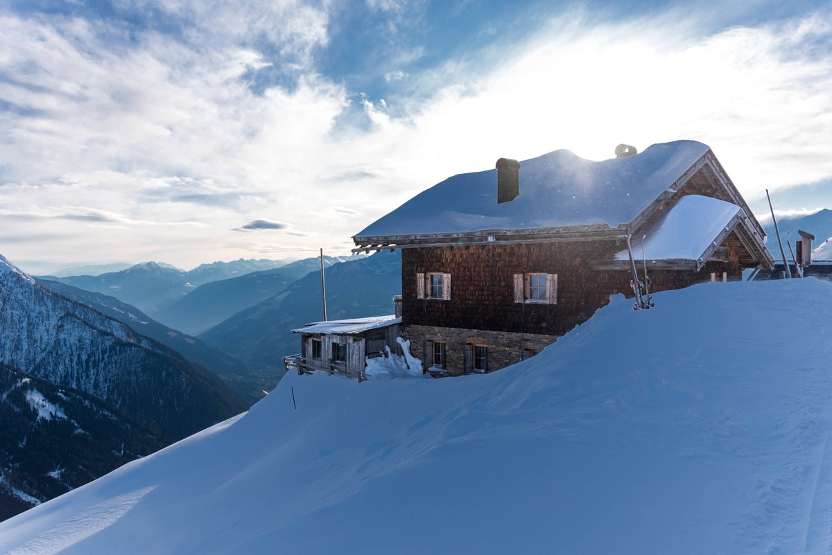 Berggasthaus Flecknerhütte auf 2100 m, Jaufenkamm, über den Jaufenpass zu erreichen, Aussicht über das Passeiertal, Ratschings-Jaufen, Südtirol, Winter, 14.02.2025, Sonnenuntergang hinter dem Berggast ...