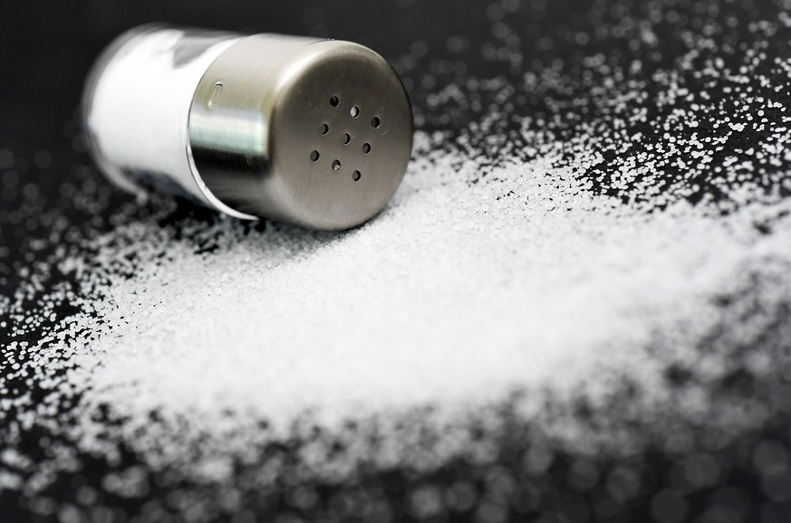 ARCHIV - 17.06.2016, Berlin: Salz und ein Salzstreuer liegen auf einem Tisch. Studien zeigen, dass zu viel Salz im Essen ungesund ist - zu wenig kann aber auch sch
