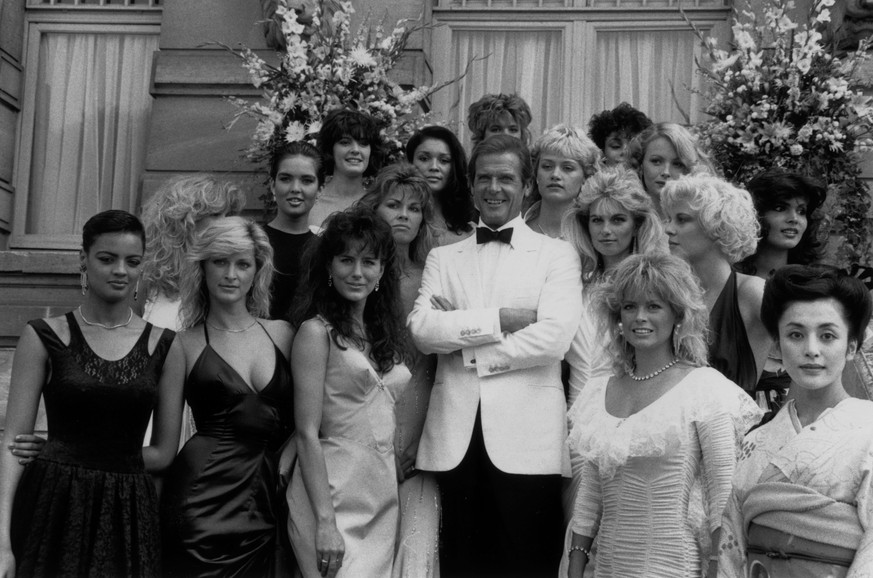 17th August 1984: Film star Roger Moore (James Bond) and the Bond Girls from the film 'View to a Kill' directed by John Glen. (Photo by Larry Ellis/Express/Getty Images)