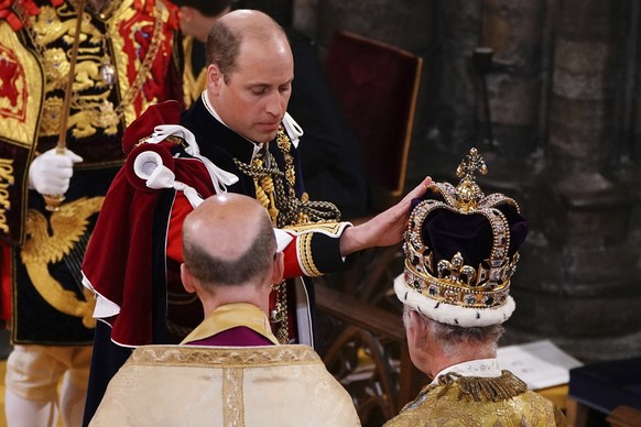 Britain&#039;s Prince William touches St Edward&#039;s Crown on King Charles III&#039;s head during his coronation ceremony in Westminster Abbey, London, Saturday May 6, 2023. (Yui Mok, Pool via AP)