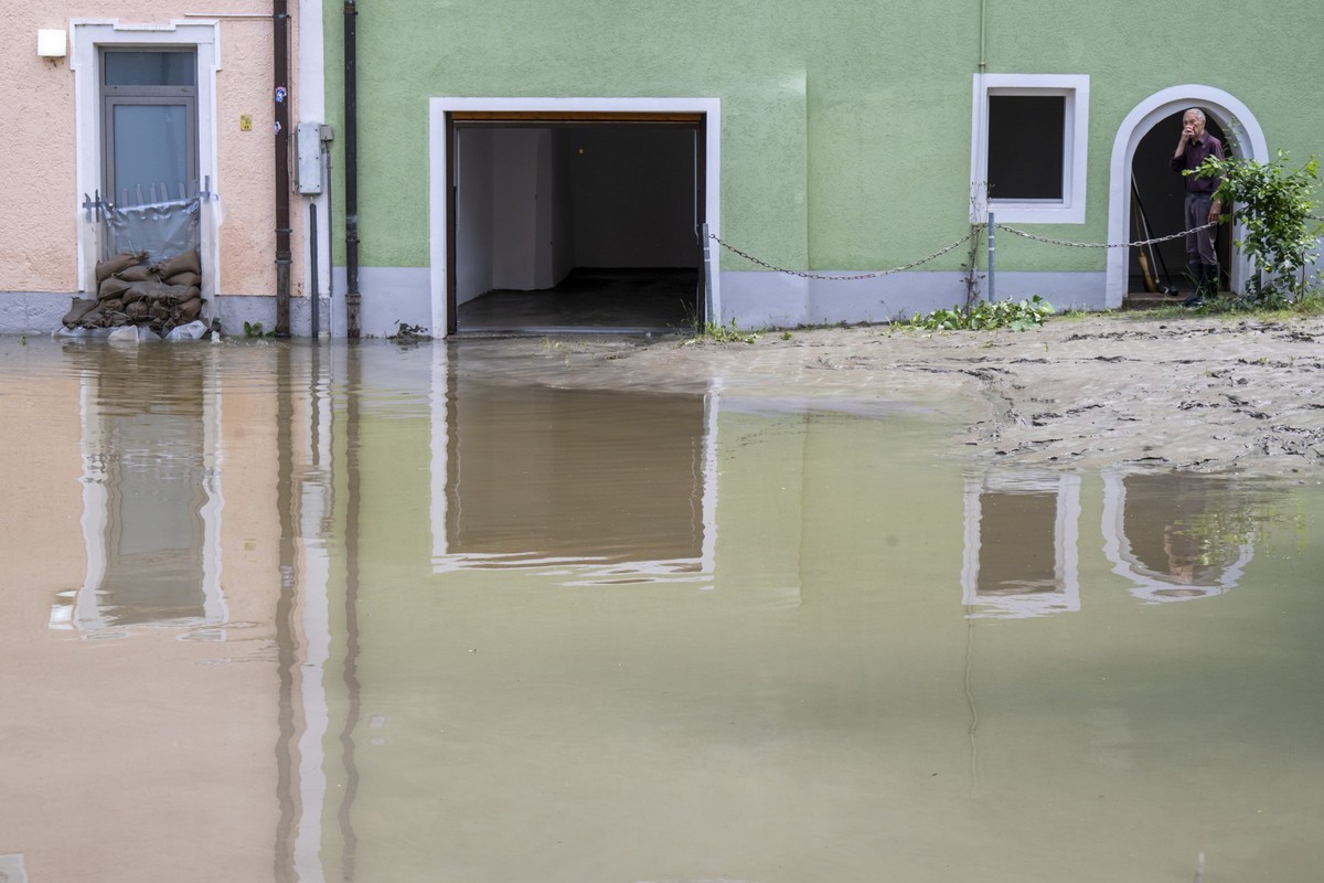 05.06.2024, Bayern, Passau: Ein Mann steht vor seinem Haus in der Dreifl�ssestadt. In Bayern herrscht nach heftigen Regenf�llen vielerorts weiter Land unter. (zu dpa: �Erste Aufr�umarbeiten in Passau  ...