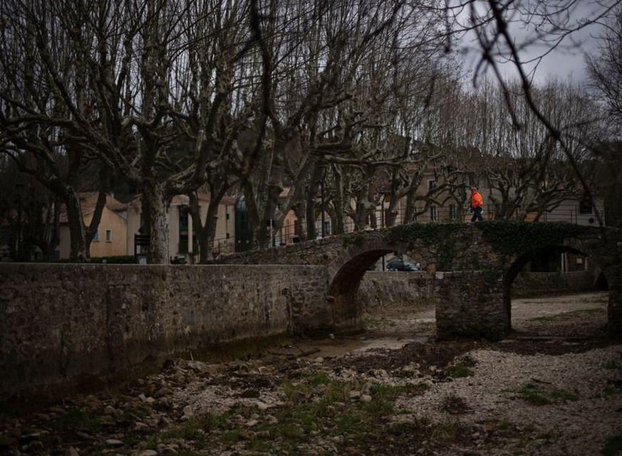 Frankreich, Flassans-sur-Issole: Ein Mann geht über ein ausgetrocknetes Flussbett. Frankreich trifft angesichts anhaltender Trockenheit Sofortmaßnahmen, um sich für einen erneuten Dürre-Sommer zu rüst ...