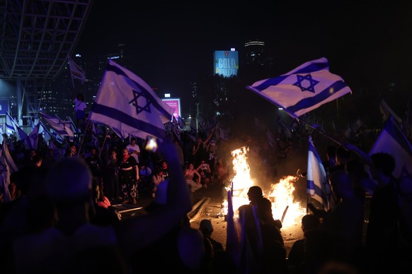 24.07.2023, Israel, Tel Aviv: Demonstranten z�nden ein Feuer an w�hrend eines Protests gegen die Justizreform. Israels Parlament hat ein Kernelement zum Umbau der Justiz im Land verabschiedet. Foto: I ...