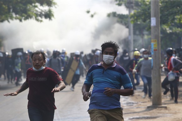 Anti-coup protesters run away when police security forces try to disperse them with tear gas in Mandalay, Myanmar, Saturday, March 13, 2021. Myanmar&#039;s military seized power Feb. 1, hours before t ...