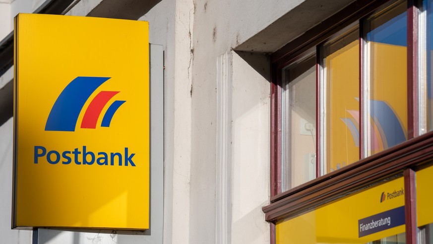 ARCHIV - 25.03.2019, Brandenburg an der Havel: Ein Schild mit dem Logo der Postbank ist an der Fassade einer Bankfiliale angebracht. Der lange Rechtsstreit zwischen einstigen Postbank-Aktion