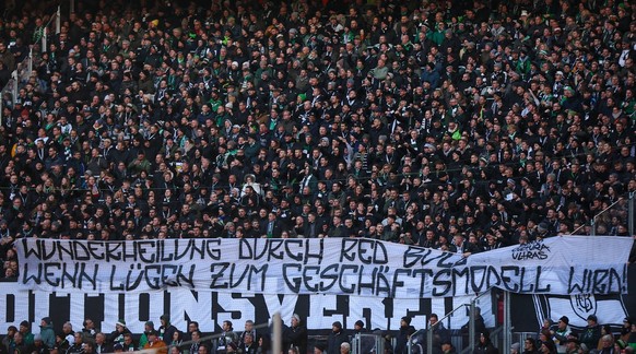 11.03.2023, Sachsen, Leipzig: Fußball: Bundesliga, 24. Spieltag, RB Leipzig - Borussia Mönchengladbach in der Red-Bull-Arena. Gladbachs Fans halten ein Schmähplakat gegen Leipzigs Sportdirektor Max Eb ...