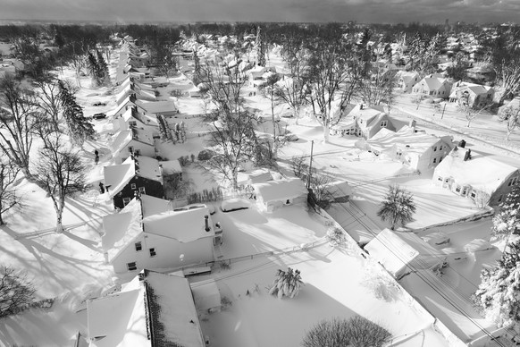 dpatopbilder - 25.12.2022, USA, Cheektowaga: Schnee bedeckt eine Nachbarschaft (Luftaufnahme mit einer Drohne). Millionen von Menschen kauerten am Sonntagmorgen vor dem tiefen Frost, um den eisigen St ...