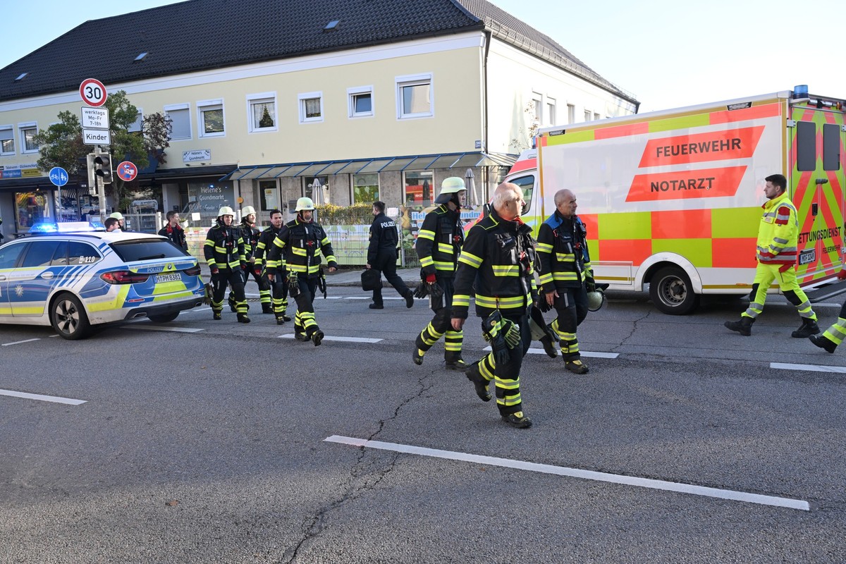 01.10.2025, Bayern, München: Polizisten, Einsatzkräfte und Fahrzeuge der Feuerwehr sind auf einer Straße zu sehen. Ein Brand in einem Münchner Einfamilienhaus hat einen Großeinsatz von Polizei und Feu ...