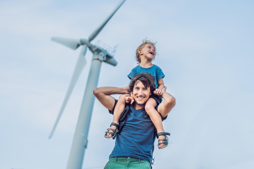 Father carrying son on shoulders and waving their arms like a windmill.