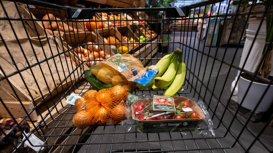 ARCHIV - 18.01.2023, Bayern, Neubiberg: Verschiedene Lebensmittel liegen in einem Supermarkt in einem Einkaufswagen. Das Statistische Bundesamt ver