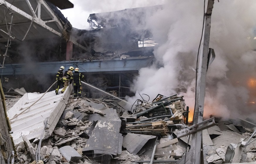 29.12.2023, Ukraine, Charkiw: Feuerwehrleute löschen ein Feuer nach einem russischen Angriff. Foto: Yevhen Titov/AP/dpa +++ dpa-Bildfunk +++