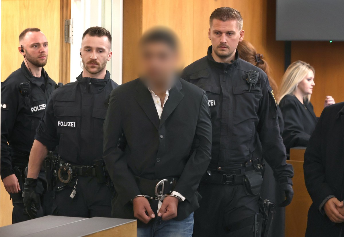 ARCHIV - 16.10.2025, Bayern, Aschaffenburg: Ein Beschuldigter (3.v.l) wird von Polizisten in einen Gerichtssaal des Landgerichtes geführt. Der Afghane soll am 22. Januar einen zweijährigen Jungen und  ...