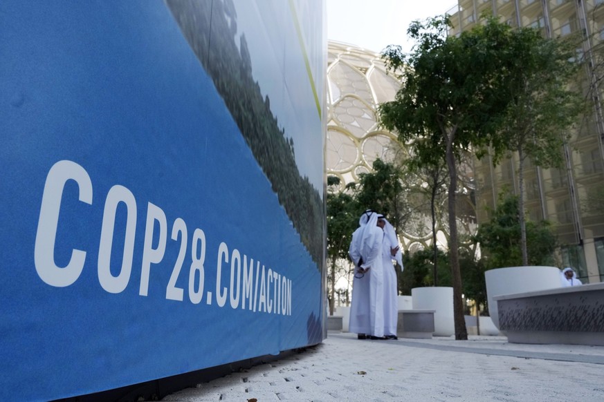 People talk near the Al Wasl Dome at Expo City ahead of the COP28 U.N. Climate Summit, Tuesday, Nov. 28, 2023, in Dubai, United Arab Emirates. (AP Photo/Peter Dejong)