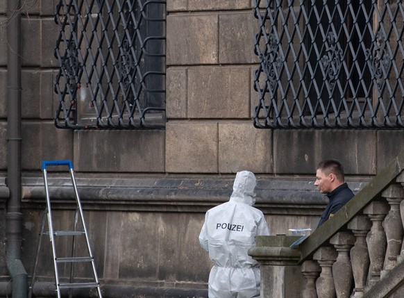 ARCHIV - 26.11.2019, Sachsen, Dresden: Einsatzkr�fte der Polizei stehen nach dem Juwelendiebstahl aus dem Gr�nen Gew�lbe neben dem durchtrennten Gitterfenster des Museums im Residenzschloss. (zu dpa � ...