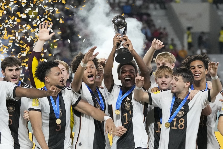 02.12.2023, Indonesien, Surakarta: Fußball, U17-Junioren: WM, Deutschland - Frankreich, Finale im Manahan Stadion. Die deutsche Mannschaft feiert nach dem Sieg auf dem Podium mit ihrem Pokal. Die deut ...