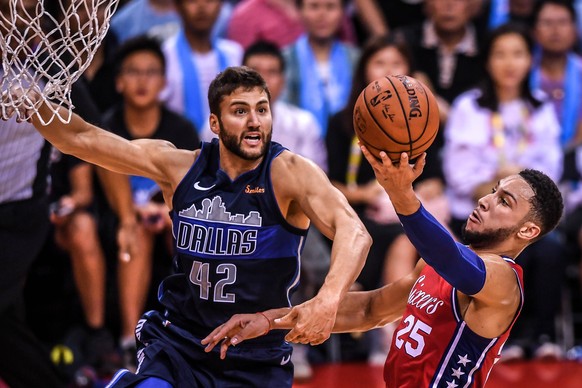 Maxi Kleber of Dallas Mavericks, left, challenges Ben Simmons of Philadelphia 76ers during the Shenzhen match of the NBA Basketball Herren USA China Games in Shenzhen city, south China s Guangdong pro ...