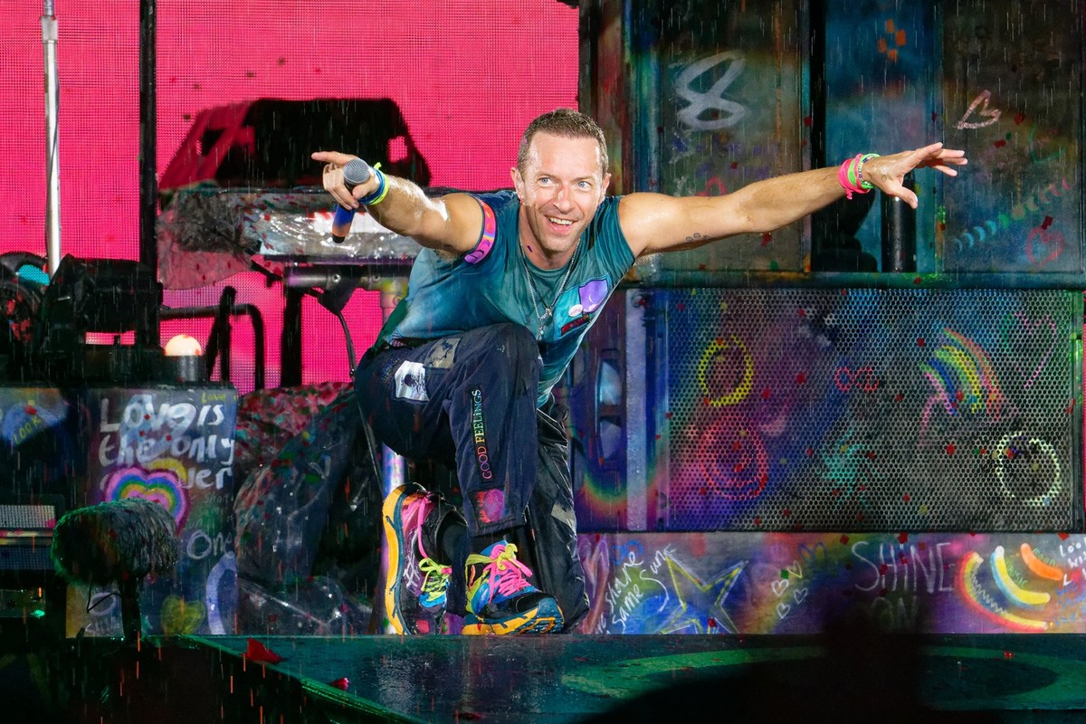 20.07.2024, Nordrhein-Westfalen, Düsseldorf: Chris Martin, Sänger der britischen Band Coldplay steht bei einem Konzert im Rahmen der &quot;Music of the Spheres Tour 2024&quot; bei strömendem Regen in  ...