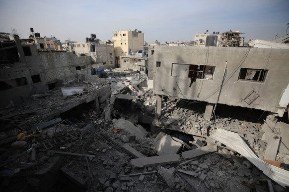 Palestinians enter a destroyed building to collect their belongings after Israeli airstrike at Bureij camp Palestinians enter a destroyed building to collect their belongings after Israeli airstrike a ...