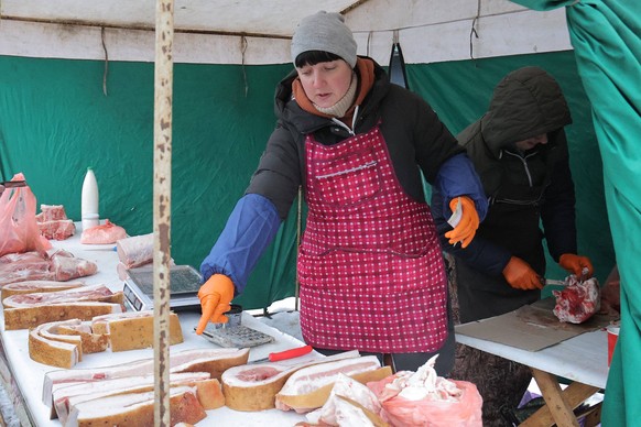 KYIV, UKRAINE - JANUARY 10, 2024 - A seller deals in meat and lard at a farmers market in Darnytska Square, Kyiv, capital of Ukraine. Farmers market in Kyiv PUBLICATIONxNOTxINxRUS Copyright: xEvgenxKo ...