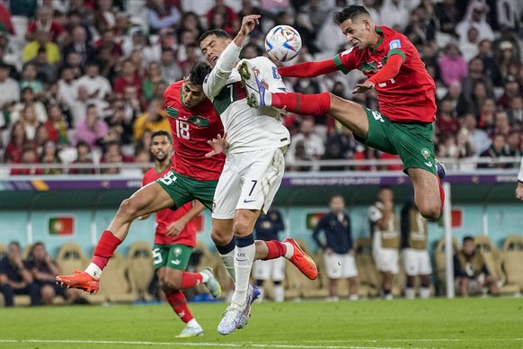 Morocco's Bilal El Khannous, right, fights for the ball with Portugal's Cristiano Ronaldo during the World Cup quarterfinal soccer match between Morocco and Portugal, at Al Thumama Stadium in Doha, Qa ...