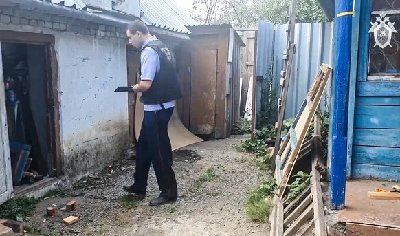 RUSSIA, CHELYABINSK REGION - JULY 31, 2023: An investigator of the Russian Investigative Committee operates in a house where, according to preliminary data, a woman who was abducted in 2009, was held  ...