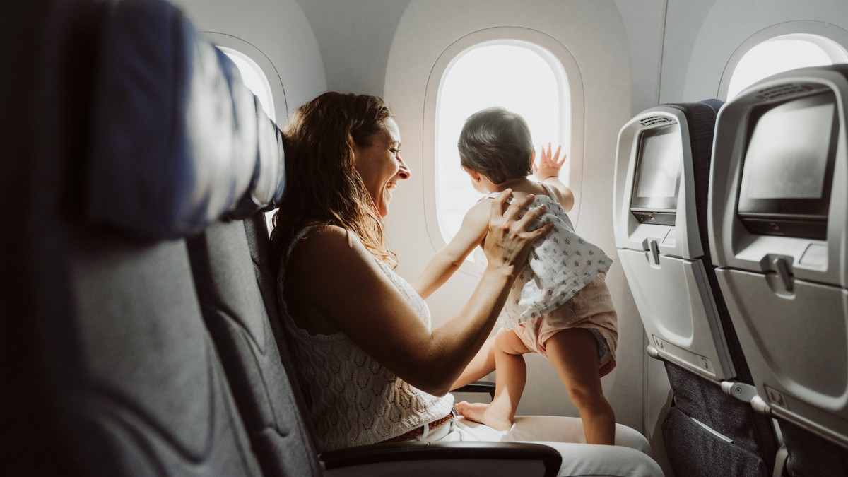 Happy mother with daughter looking through airplane window model released, Symbolfoto, EBBF09070